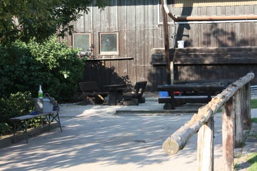 Holzterrasse mit Sitzbänken vor dem Reiterstüberl
